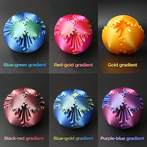 May include: Six different color gradient metal spheres with a gear design. The spheres are blue-green, red-gold, gold, black-red, blue-gold, and purple-blue.