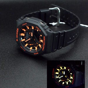 CASIO G-Shock GA-2100, costellazione arancione dipinta a mano. Custodia nera personalizzata.