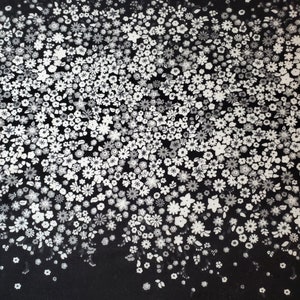 May include: Black fabric with a white floral pattern. The flowers are small and scattered randomly across the fabric. The pattern is denser at the top and fades out towards the bottom.
