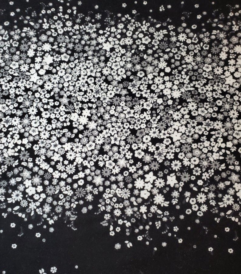 May include: Black fabric with a white floral pattern. The flowers are small and scattered randomly across the fabric. The pattern is denser at the top and fades out towards the bottom.