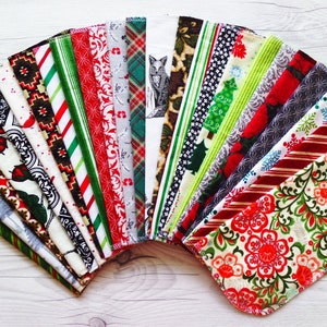 May include: A collection of 20 fabric squares with various Christmas-themed patterns, including red and green stripes, snowflakes, and floral designs.