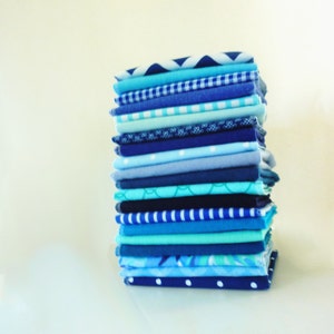 A stack of 20 mixed blue pattern and color reusable paper towels.  Patterns include floral, stripe, dot, gingham, whimsical print.  Solid colors include 10 different blue hues.
