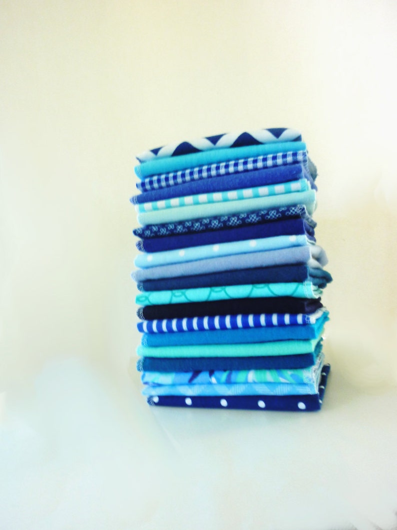 A stack of 20 mixed blue pattern and color reusable paper towels.  Patterns include floral, stripe, dot, gingham, whimsical print.  Solid colors include 10 different blue hues.