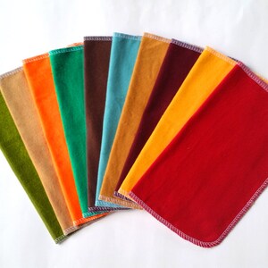 May include: A set of ten fabric swatches in various colors, including green, orange, brown, blue, yellow, and red. The swatches are arranged in a fan shape, with the red swatch at the bottom.