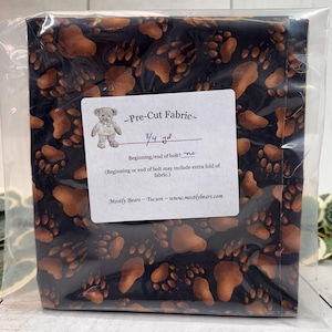 A single 3/4-yard precut of 100 percent cotton fabric Bear Tracks on Black Background.