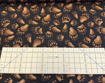 100 percent cotton fabric Bear Tracks on Black Background. Quantity 1= fat quarter. Greater than 1 is a continuous cut.