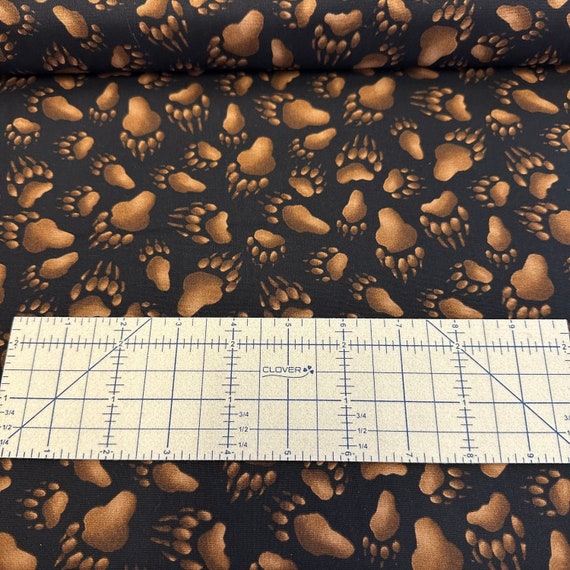 100 percent cotton fabric Bear Tracks on Black Background. Quantity 1= fat quarter. Greater than 1 is a continuous cut.
