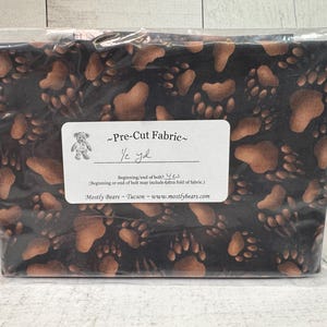 A single 1/2-yard precut of 100 percent cotton fabric Bear Tracks on Black Background.