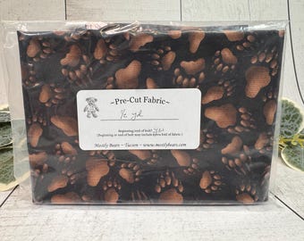 A single 1/2-yard precut of 100 percent cotton fabric Bear Tracks on Black Background.