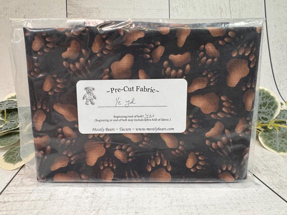 A single 1/2-yard precut of 100 percent cotton fabric Bear Tracks on Black Background.