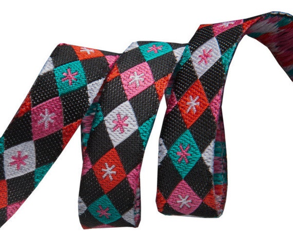 3/8-inch woven jacquard ribbon, argyle and stars on black background.