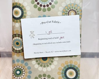 A 1-yard precut of 100 percent cotton fabric Beige with multicolor circles.