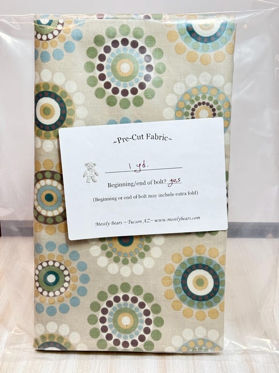 A 1-yard precut of 100 percent cotton fabric Beige with multicolor circles.