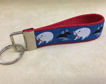 A key fob, gorgeous jacquard ribbon. Polar Bears, blue background, red webbing.