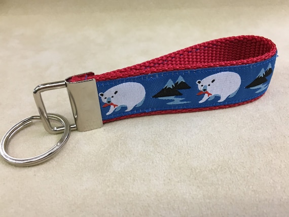 A key fob, gorgeous jacquard ribbon. Polar Bears, blue background, red webbing.