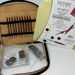 Peut inclure: Un jeu d'aiguilles circulaires interchangeables Knitters Pride Cubics Symfonie Rose dans un étui zippé noir. L'ensemble comprend des aiguilles de 40 cm, des cordons à code couleur et des accessoires. Les aiguilles sont en bois de rose poli et ont des pointes nickelées.