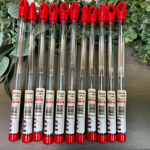 May include: Ten clear plastic tubes with red caps containing sets of knitting needles. Each tube is labeled with the size of the needles in millimeters and US sizes. The sizes are 2.0mm US 0, 2.25mm US 1, 2.5mm US 1.5, 2.75mm US 2, 3.0mm US 2, 3.25mm US 3, 3.5mm US 4, 3.75mm US 4, 4.0mm US 6, 4.5mm US 7, and 5.0mm US 8.