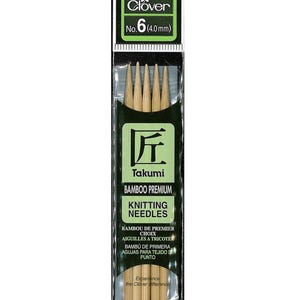 May include: A packet of Clover Takumi bamboo knitting needles, size 6 (4.0 mm), 13cm long. The needles are light brown and packaged in a clear plastic sleeve with a green and black label.