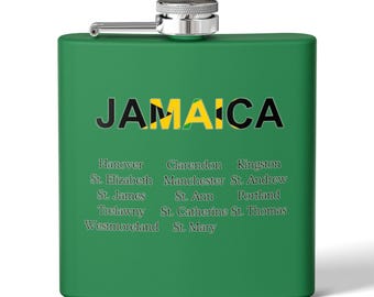 May include: A green metal flask with a silver cap. The flask has the word "JAMAICA" printed on it in black letters with the Jamaican flag colors in the background. Below the word "JAMAICA" are the names of the parishes of Jamaica.