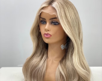 May include: A long, wavy blonde wig with light brown highlights. The wig is styled in a loose, natural wave and falls to the shoulders.