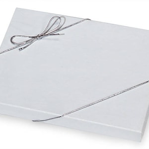 May include: A white gift box with a silver ribbon tied in a bow.