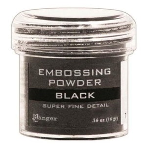 May include: A small, clear plastic jar of black embossing powder. The label reads "Embossing Powder Black Super Fine Detail Ranger .56 oz (16 gr)"