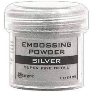 May include: A clear plastic jar of silver embossing powder. The label reads "Embossing Powder Silver Super Fine Detail Ranger 1 oz (34 ml)"