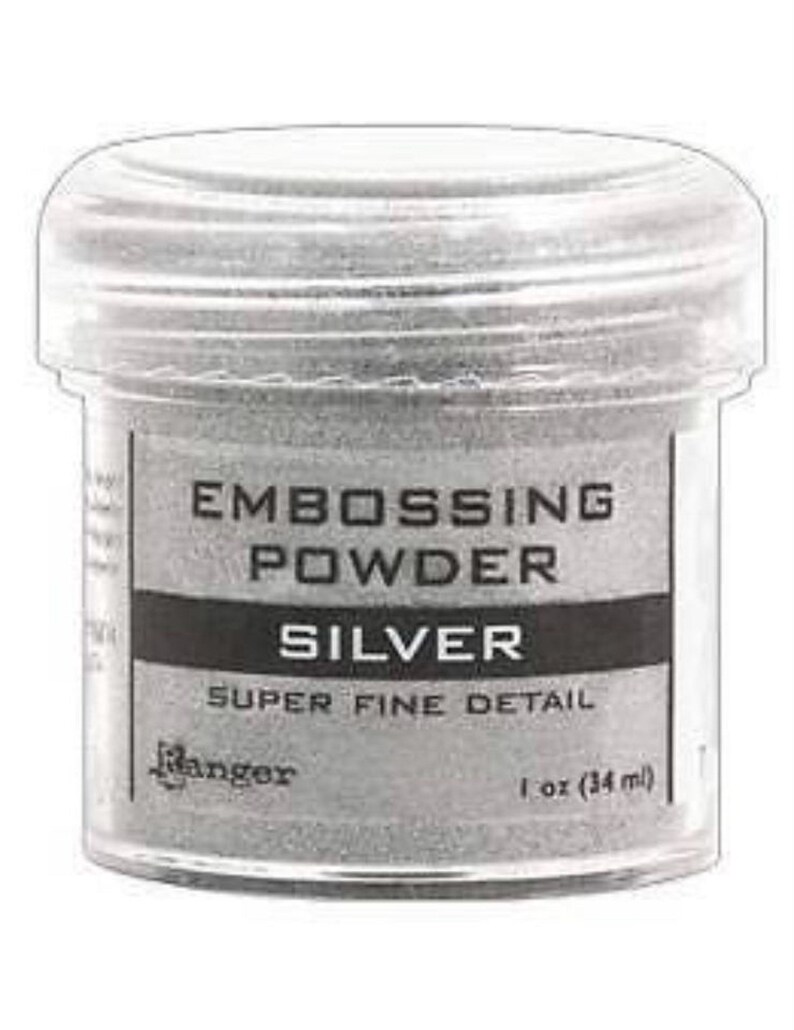 May include: A clear plastic jar of silver embossing powder. The label reads "Embossing Powder Silver Super Fine Detail Ranger 1 oz (34 ml)"