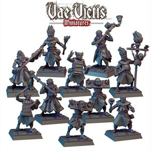May include: A set of 10 hand-painted miniature figures, depicting a group of individuals in various poses, wearing robes and holding different objects. The figures are painted in shades of gray and brown, with some details in white. The figures are standing on circular bases.