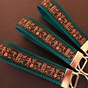 HIEROGLYPH Key Fob. Jacquard fob black, tan, green on teal. Silver nickel hardware. Wristlet. Key chain. 1&quot; wide, Ancient Egypt, African