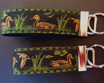 DUCKS Key Fob. Jacquard fob green, tan on black. Silver nickel hardware. Wristlet. Key chain. 1 1/4" wide, Wildlife, fowl