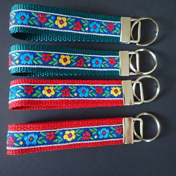 MORAVIAN DAISY Key Fob. Red, blue, yellow flowers on periwinkle blue, on red  or green webbing. Wristlet. Key chain. 1" wide, Choice of size