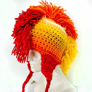 Peut inclure: Un chapeau crocheté avec un design de style mohawk. Le chapeau est fait de fil rouge et jaune et a un sommet long et pointu.