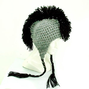 May include: Gray and black crocheted hat with a long black and gray braid and a black mohawk style top.