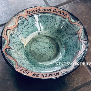May include: A green ceramic bowl with a copper-coloured rim and inscription. The inscription reads "David and Donna March 24, 1973" and "NINGS WONDERWORLD".