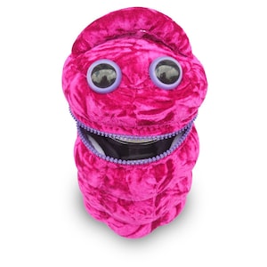 May include: A plush pink and purple creature with large eyes and a zippered mouth. The creature is a small, soft toy with a zippered opening that reveals a black interior.