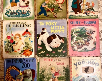 Könnte beinhalten: Eine Sammlung von neun Vintage-Little-Golden-Büchern mit bunten Umschlägen, die Illustrationen von Kindern, Tieren und Szenen aus klassischen Märchen zeigen. Die Titel lauten: "Hänsel und Gretel", "Die Glückliche Familie", "Onkel Remus", "Das Flauschige Entlein", "Der Langsame Kleine Welpe", "Scuffy der Schlepper", "Das Picknick im Zoo", "Peter Bekommt Seinen Wunsch" und "Ein Fernsehbuch von Yoo-Hoo".