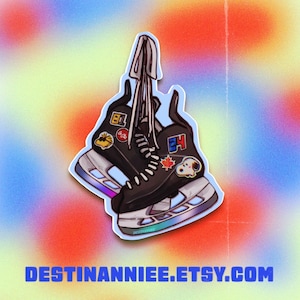 May include: A sticker featuring two black ice skates with white laces and silver blades. The skates have patches with cartoon characters and logos. The background is a colorful gradient with the text DESTINANNIEE.ETSY.COM.