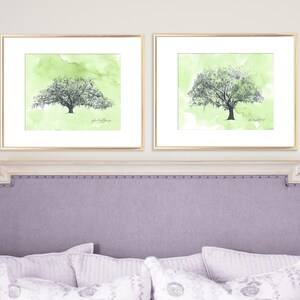 May include: Two framed watercolor paintings of green trees with a light green background. The trees have a dark gray outline and are framed in gold.
