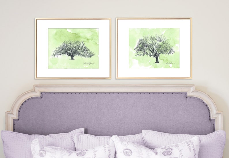 May include: Two framed watercolor paintings of green trees with a light green background. The trees have a dark gray outline and are framed in gold.