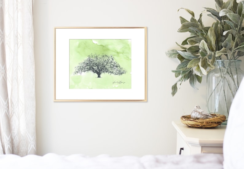 May include: A framed watercolor painting of a large tree with green foliage and a light green background. The text "plant a tree" is written in cursive at the bottom of the painting.