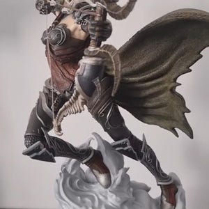 Peut inclure: Une figurine détaillée d'une elfe archer, tenant un arc et une flèche, avec une cape verte flottante et une base en forme de nuage blanc. La figurine est peinte dans des tons de brun, noir et vert.