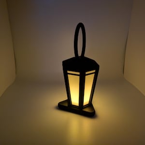 May include: A black metal lantern with a white frosted glass panel and a warm yellow light inside.