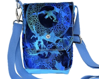 May include: A small blue crossbody bag with a dragon and Celtic knot design. The bag has a flap closure and an adjustable strap.