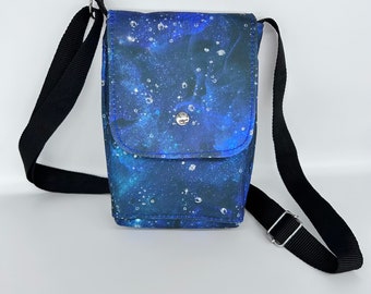 Small cross body bag with adjustable strap,  Blue galaxy print waterproof canvas, Inside and outside pockets. Front flap and magnetic snap