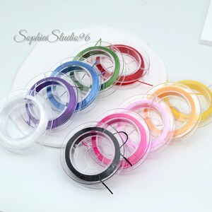 May include: Spools of colorful beading thread in various colors, including white, purple, blue, red, green, pink, orange, yellow, and black. The spools are clear plastic and arranged in a circular pattern. The text "Sophia Studio96" is in the upper left.