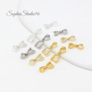 May include: A collection of jewelry findings in silver and gold tones. The findings are small, with a loop at the top and a curved, open bottom. The text "Sophia Studio96" is in the upper left corner.
