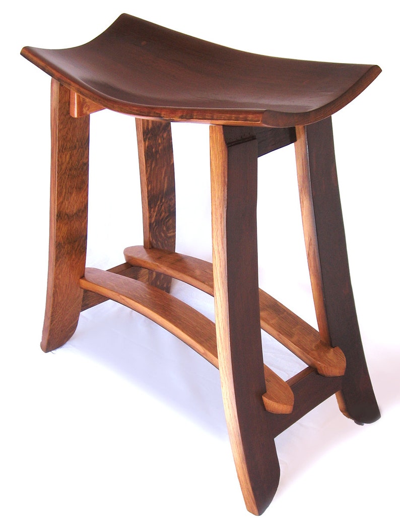 May include: A dark brown wooden stool with a curved seat and a unique, open-frame design. The stool has two horizontal supports and a curved, open-frame base.