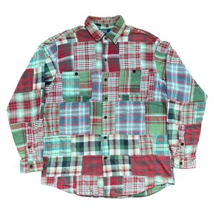 Op de afbeelding: Een patchwork shirt met lange mouwen in verschillende ruitpatronen. Het shirt heeft een knoopsluiting, een kraag en manchetten met knopen. Het kleurenpalet omvat rood, groen, blauw en wit.