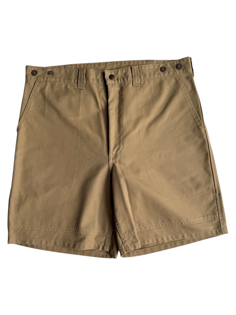 Puede incluir: Pantalones cortos color caqui con cierre de bot&oacute;n y trabillas para el cintur&oacute;n. Los pantalones cortos tienen un dise&ntilde;o cl&aacute;sico con pernera recta y corte entallado. Fabricados con tejido duradero, adecuados para ropa informal. Miden unos 40 cm.